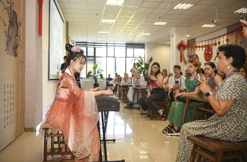 　　在新疆图书馆，乌鲁木齐古筝爱好者为国外歌舞团演员演奏《渔舟唱晚》（7月23日摄）。新华社记者 胡虎虎 摄